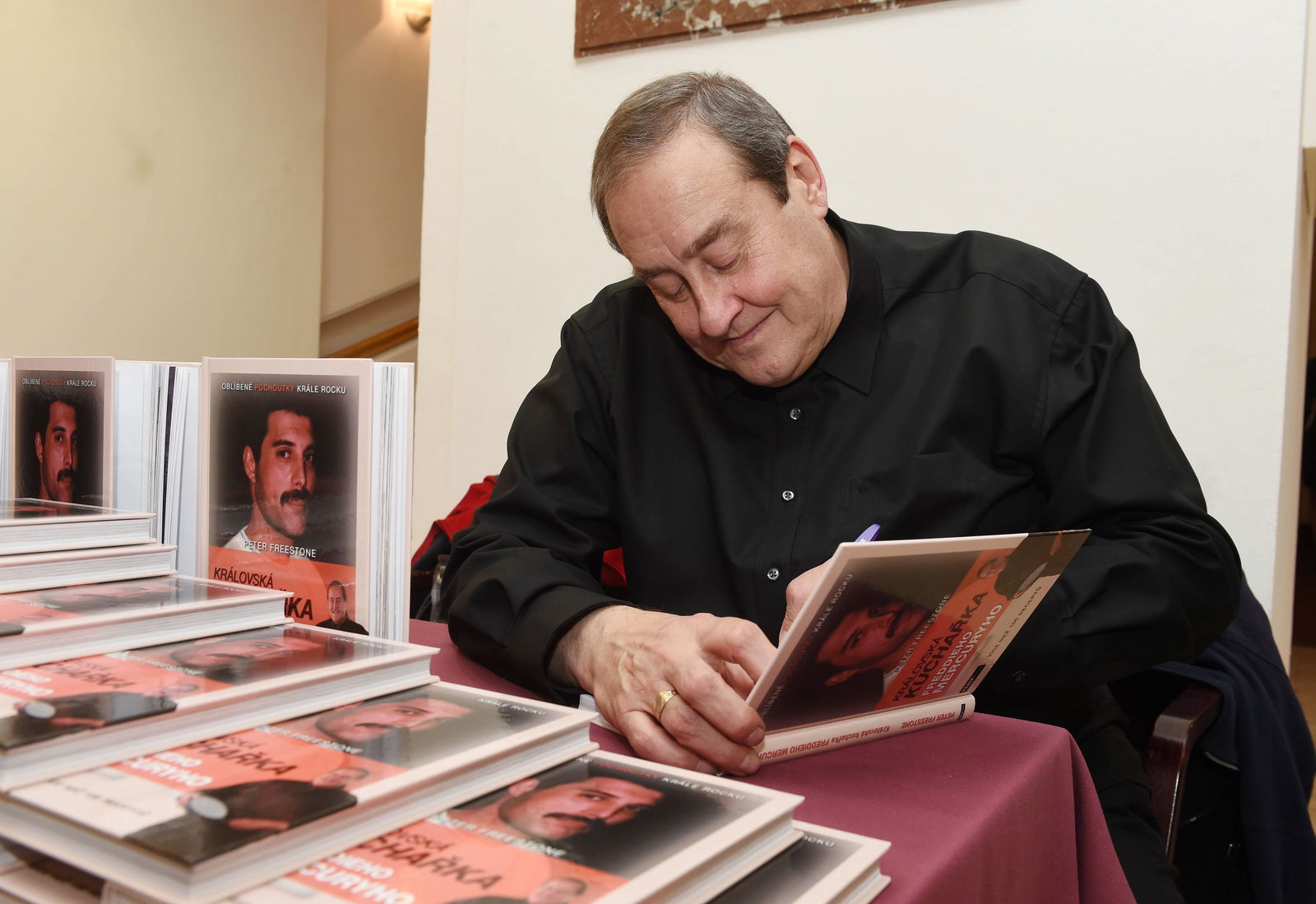 Peter Freestone signiert das königliche Kochbuch von Freddie Mercury (2016)